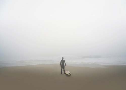 san diego man standing beside surfboard on seashore united states